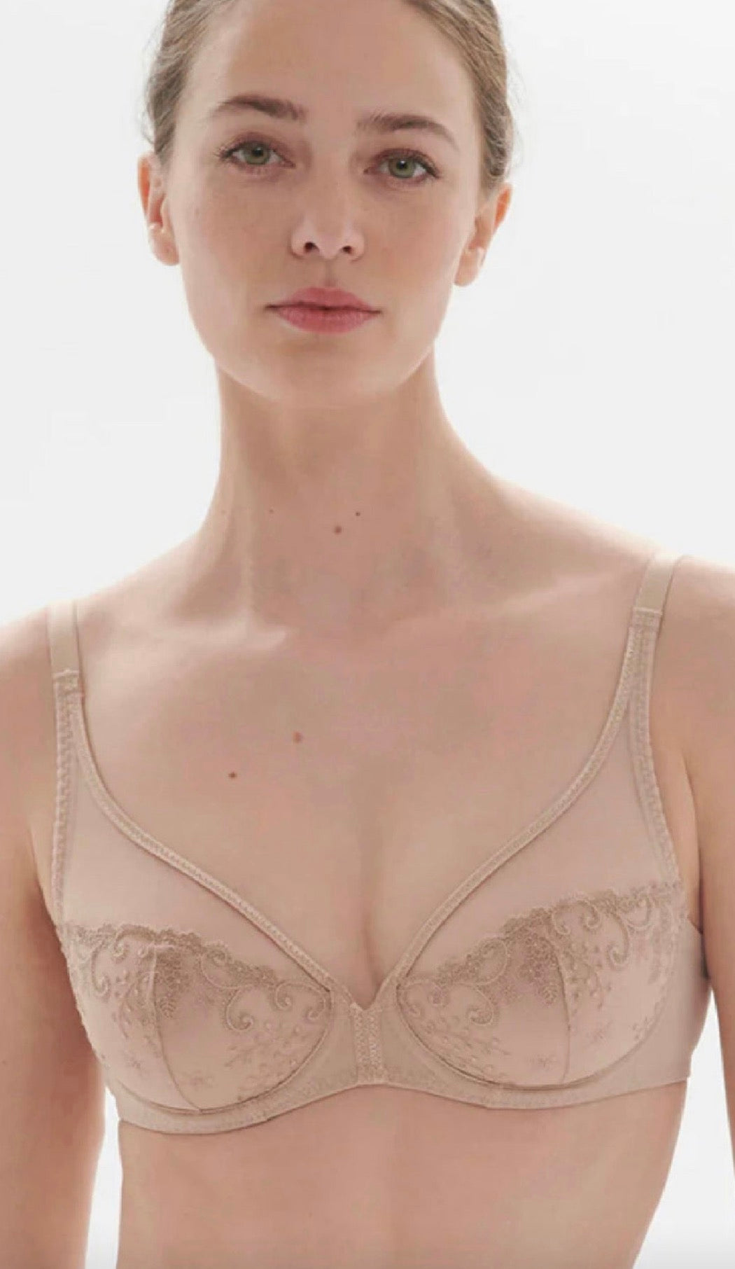 Woman wearing a well-fitted nude lace bra, front view
