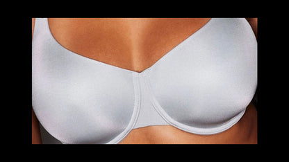 Woman wearing a white bra against a dark background